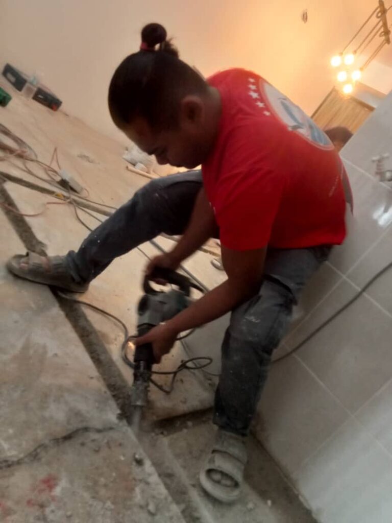 Menebuk lantai untuk proses pemasangan saluran paip yang baru