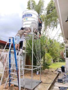 Proses pemasangan tangki air aluminium di luar rumah